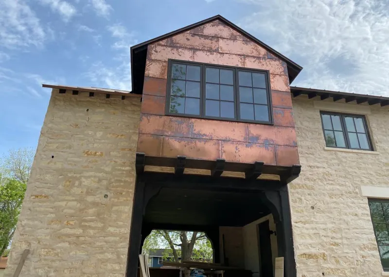 Copper metal panel facade on a stone building for Roof Repair in Russellville
